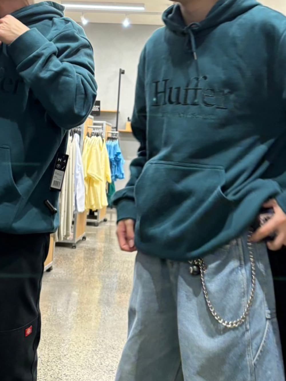 ブルー系のデニムパンツ、ブラック系のスニーカー、グリーン系のパーカーを着用したメンズの春コーディネートの2枚目の写真