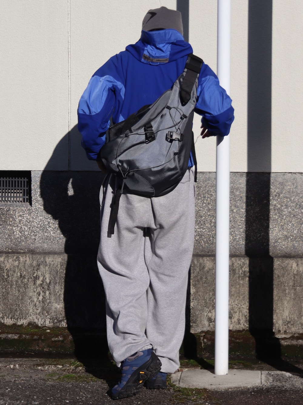 グレー系のスニーカー、グレー系のショルダーバッグ、ブルー系のジャケット/アウターを着用したメンズの秋コーディネートの2枚目の写真