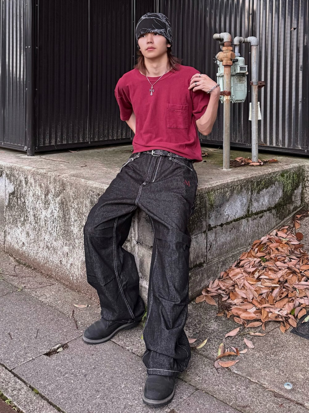 レッド系のTシャツ/カットソー、ブラック系のデニムパンツ、ブラック系のブーツを着用したメンズの夏コーディネートの3枚目の写真