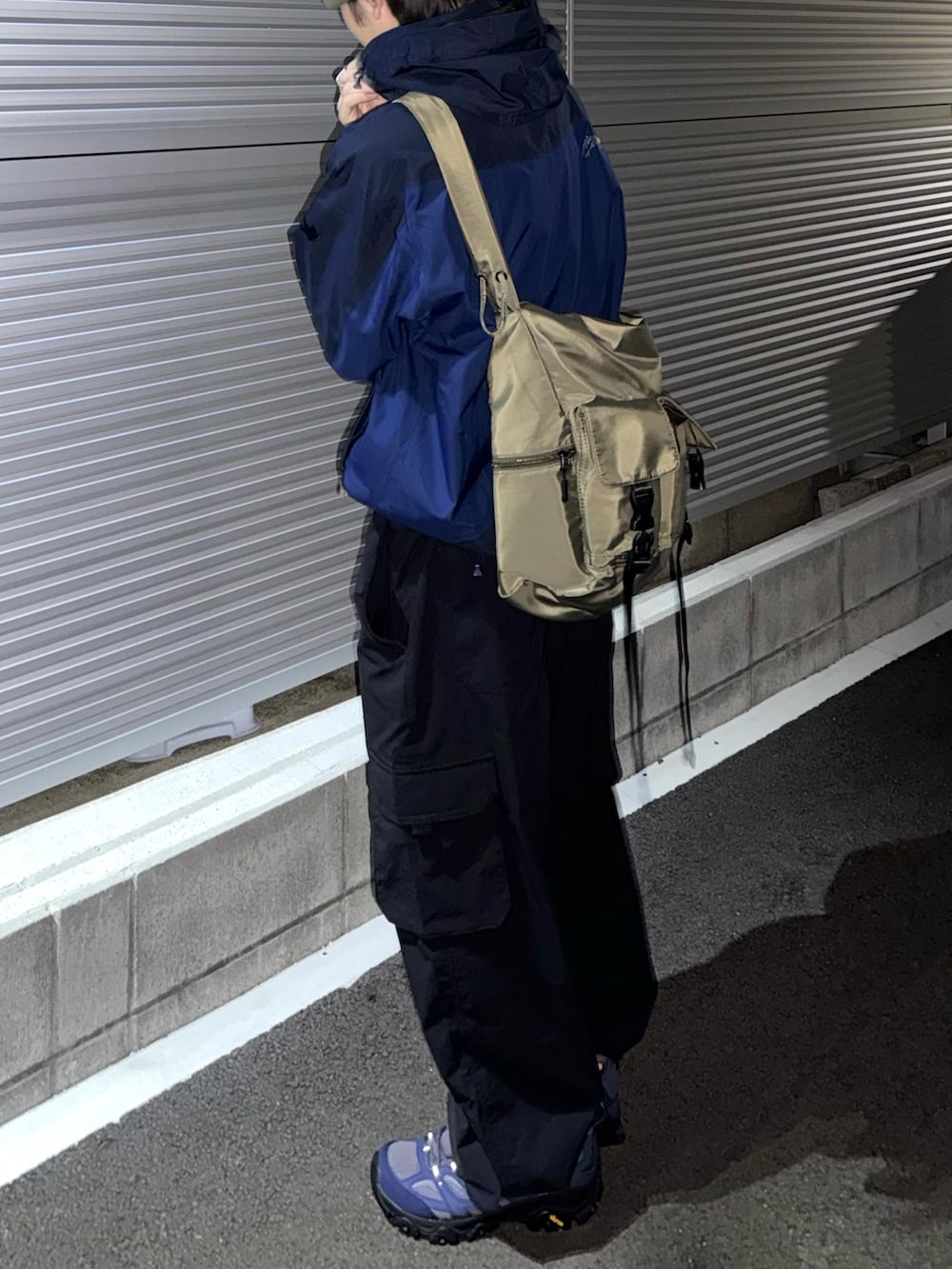 グレー系のスニーカー、ブラック系のカーゴパンツ、グリーン系のショルダーバッグを着用したメンズの秋コーディネートの3枚目の写真