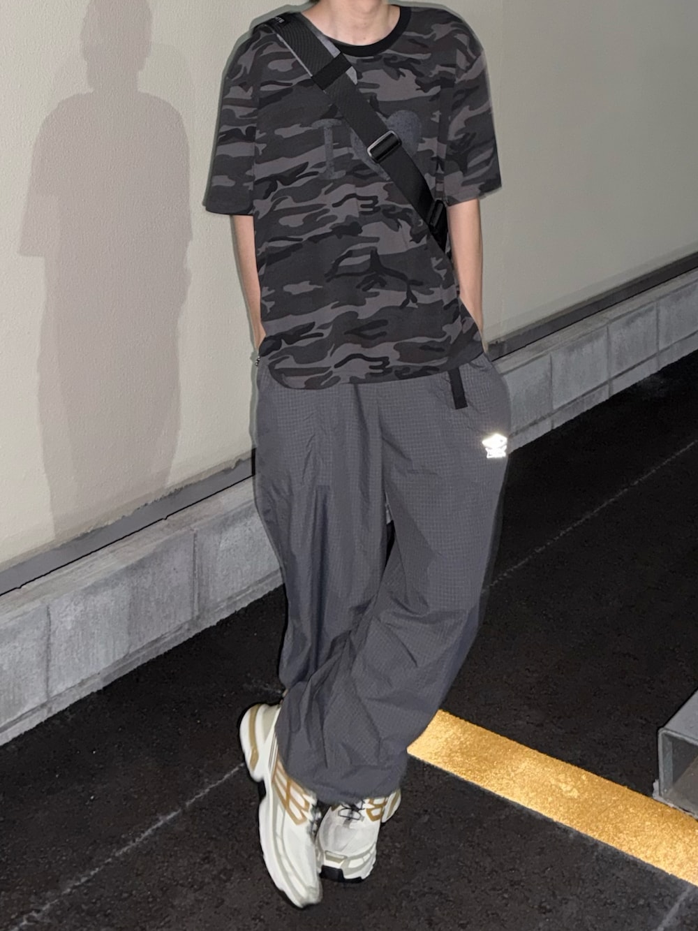 グレー系のTシャツ/カットソー、グレー系のカーゴパンツ、ホワイト系のスニーカーを着用したメンズの夏コーディネートの2枚目の写真