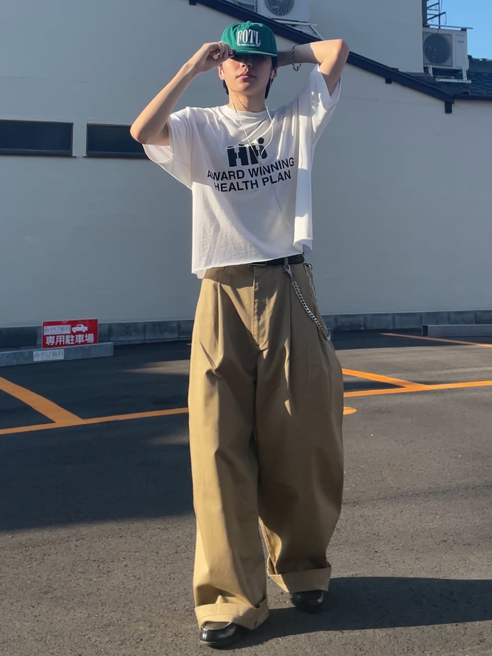 ベージュ系のチノパンツ、ホワイト系のTシャツ/カットソー、ブラック系のローファーを着用したメンズの夏コーディネートの2枚目の写真