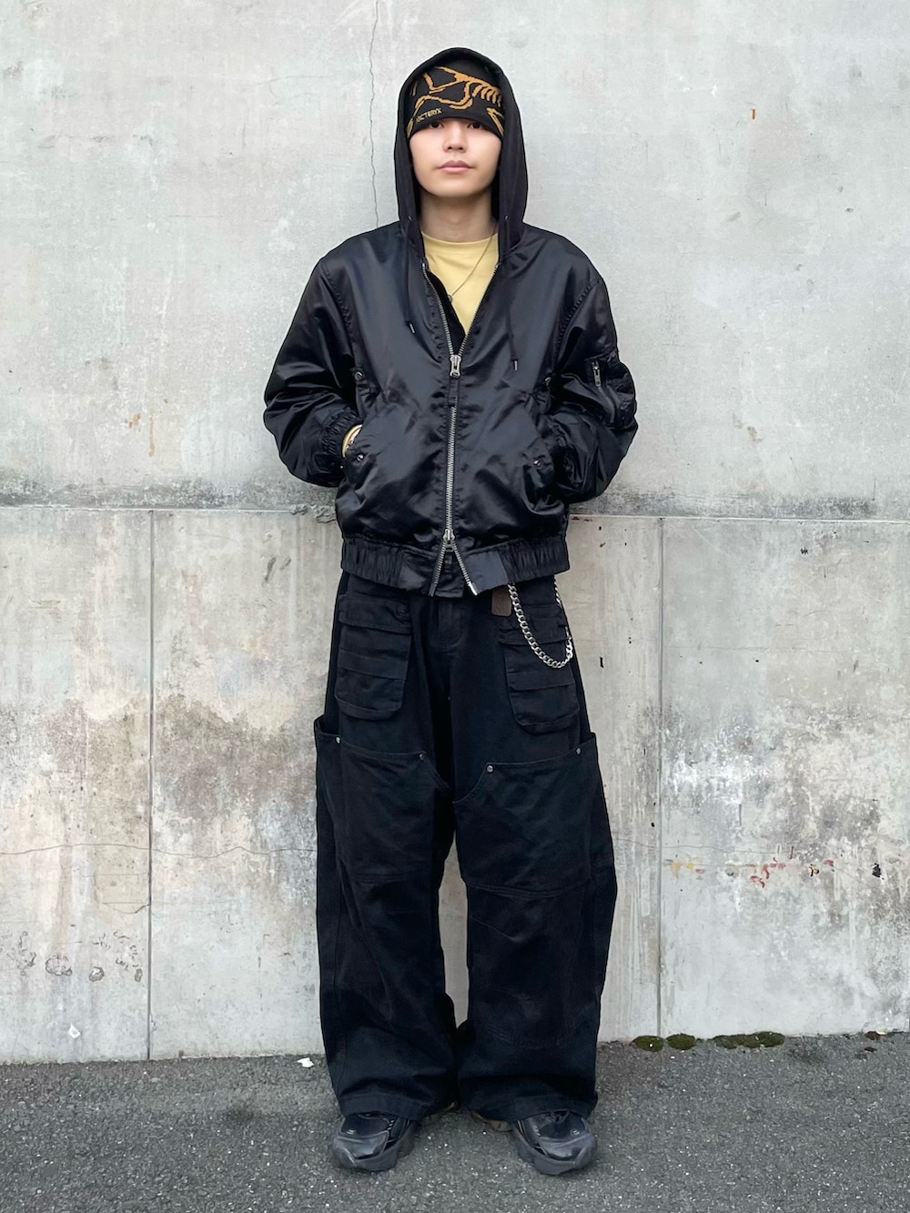 ブラック系のブルゾン、イエロー系のTシャツ/カットソー、ブラック系のカーゴパンツを着用したメンズの秋コーディネートの3枚目の写真