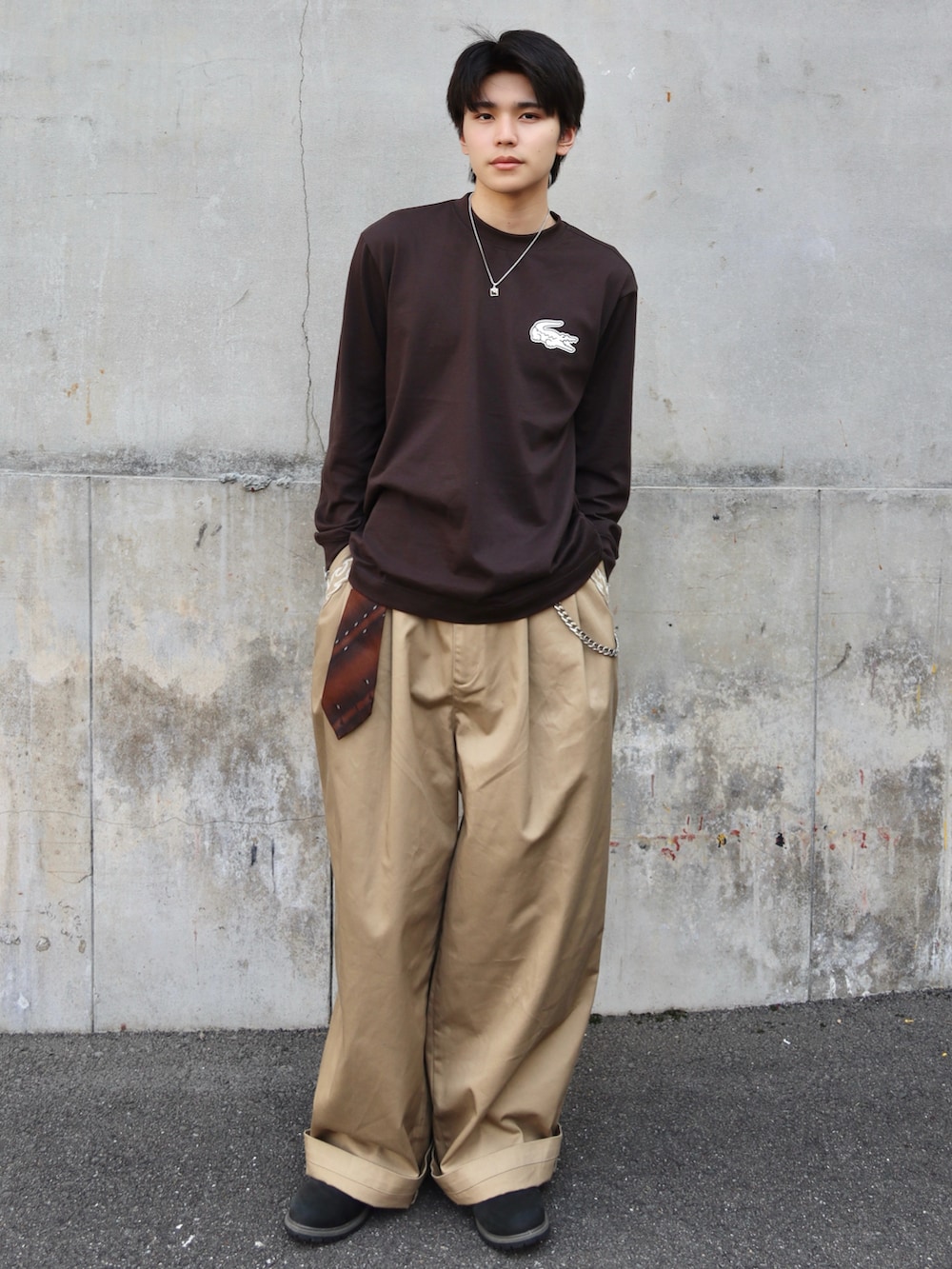ブラウン系のTシャツ/カットソー、ベージュ系のチノパンツ、ブラウン系のネクタイを着用したメンズの秋コーディネートの3枚目の写真