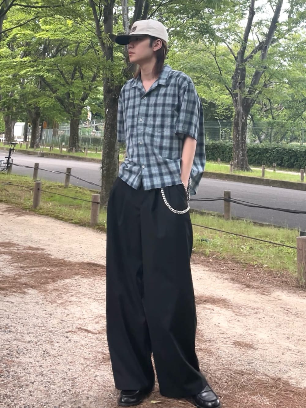 ブラック系のスラックス、ブルー系のシャツ/ブラウス、ブラック系のローファーを着用したメンズの夏コーディネートの2枚目の写真