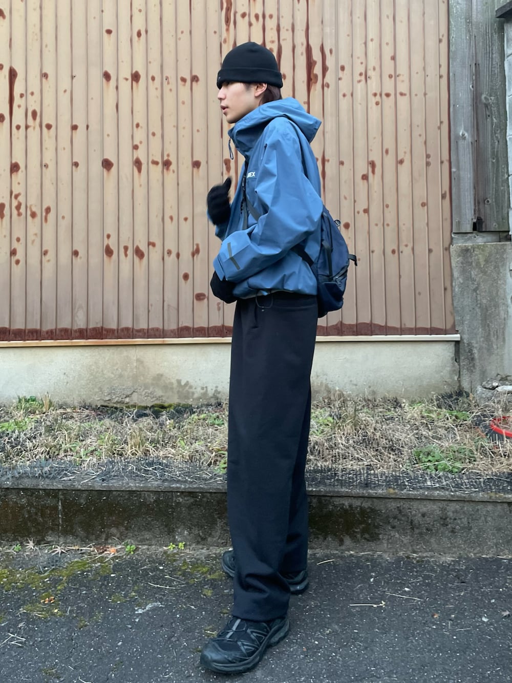 ブラック系のスニーカー、ブルー系のショルダーバッグ、ブラック系のスウェットパンツを着用したメンズの冬コーディネートの3枚目の写真