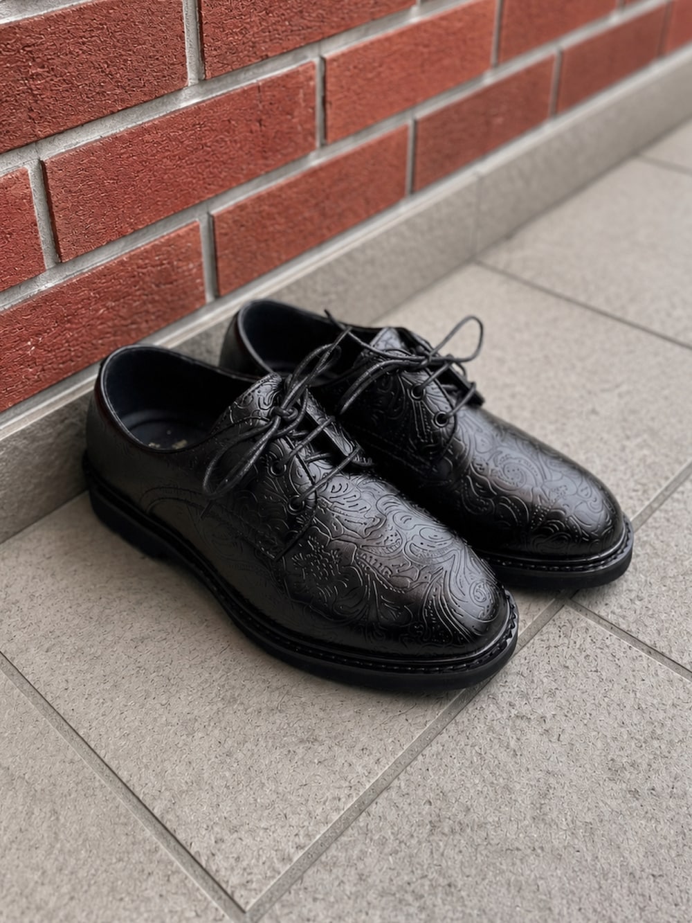 ブラック系のショルダーバッグ、ブルー系のデニムパンツ、ブラック系のドレスシューズを着用したメンズの夏コーディネートの5枚目の写真