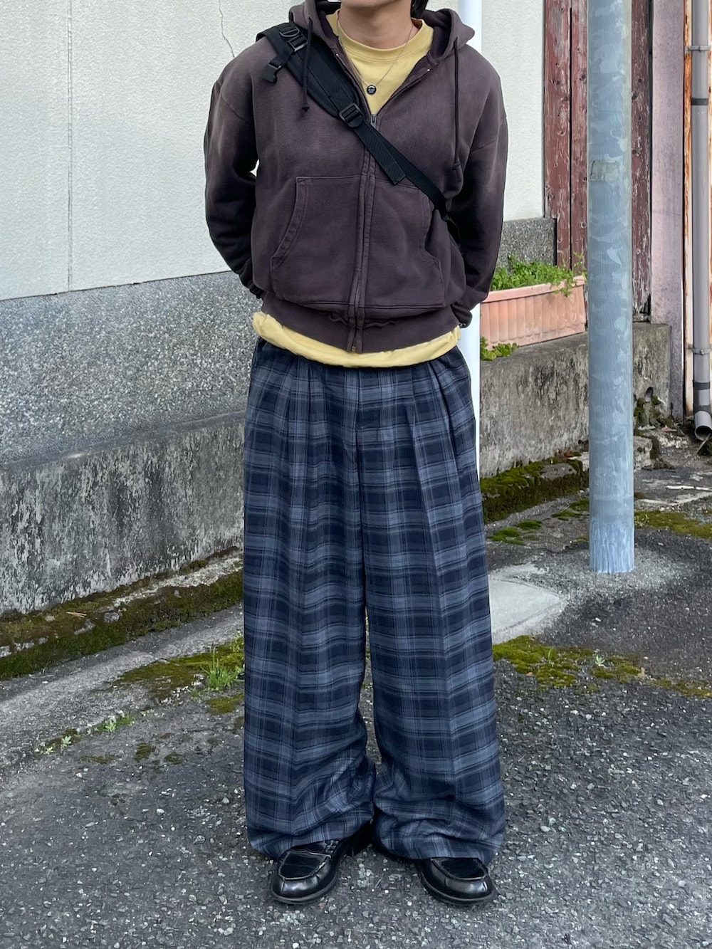 ブルー系のスラックス、イエロー系のTシャツ/カットソー、ブラック系のローファーを着用したメンズの春コーディネートの3枚目の写真