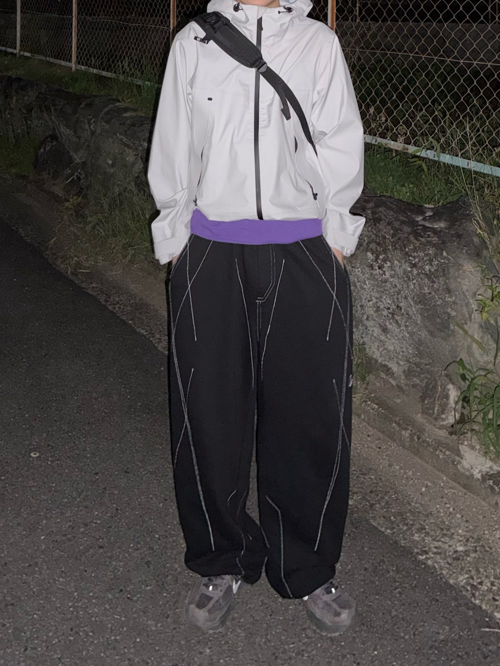 グレー系のスニーカー、パープル系のTシャツ/カットソー、ブラック系のスウェットパンツを着用したメンズの秋コーディネートの3枚目の写真