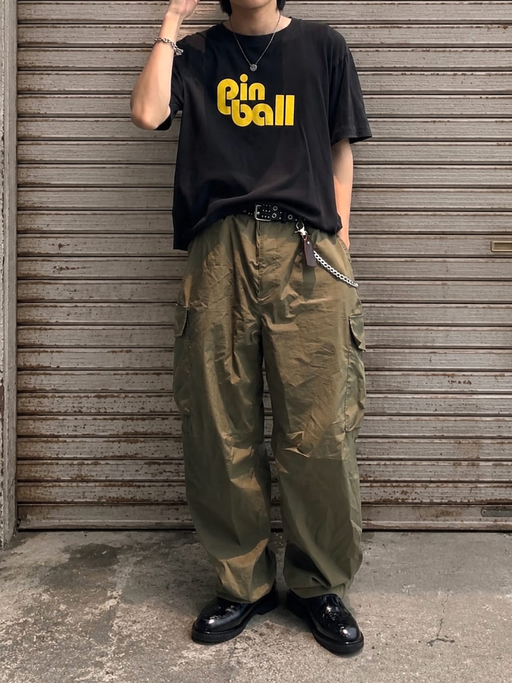 ブラック系のドレスシューズ、グリーン系のカーゴパンツ、ブラック系のTシャツ/カットソーを着用したメンズの夏コーディネートの3枚目の写真