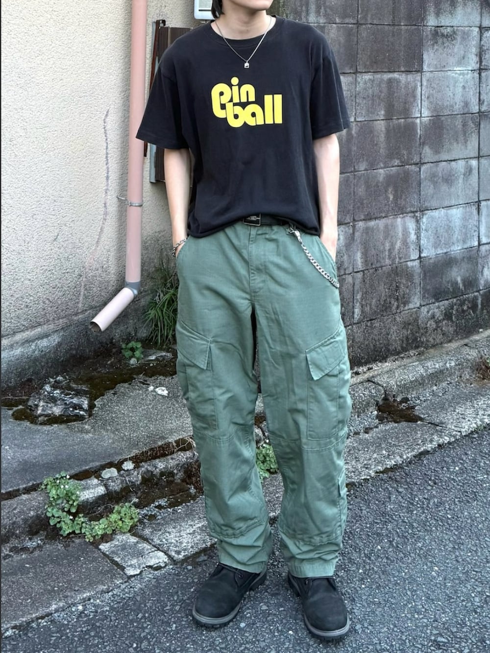 ブラック系のブーツ、ブラック系のTシャツ/カットソー、グリーン系のカーゴパンツを着用したメンズの夏コーディネートの3枚目の写真