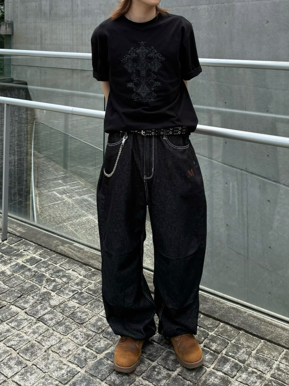 ブラウン系のブーツ、ブラック系のTシャツ/カットソー、ブラック系のデニムパンツを着用したメンズの夏コーディネートの3枚目の写真