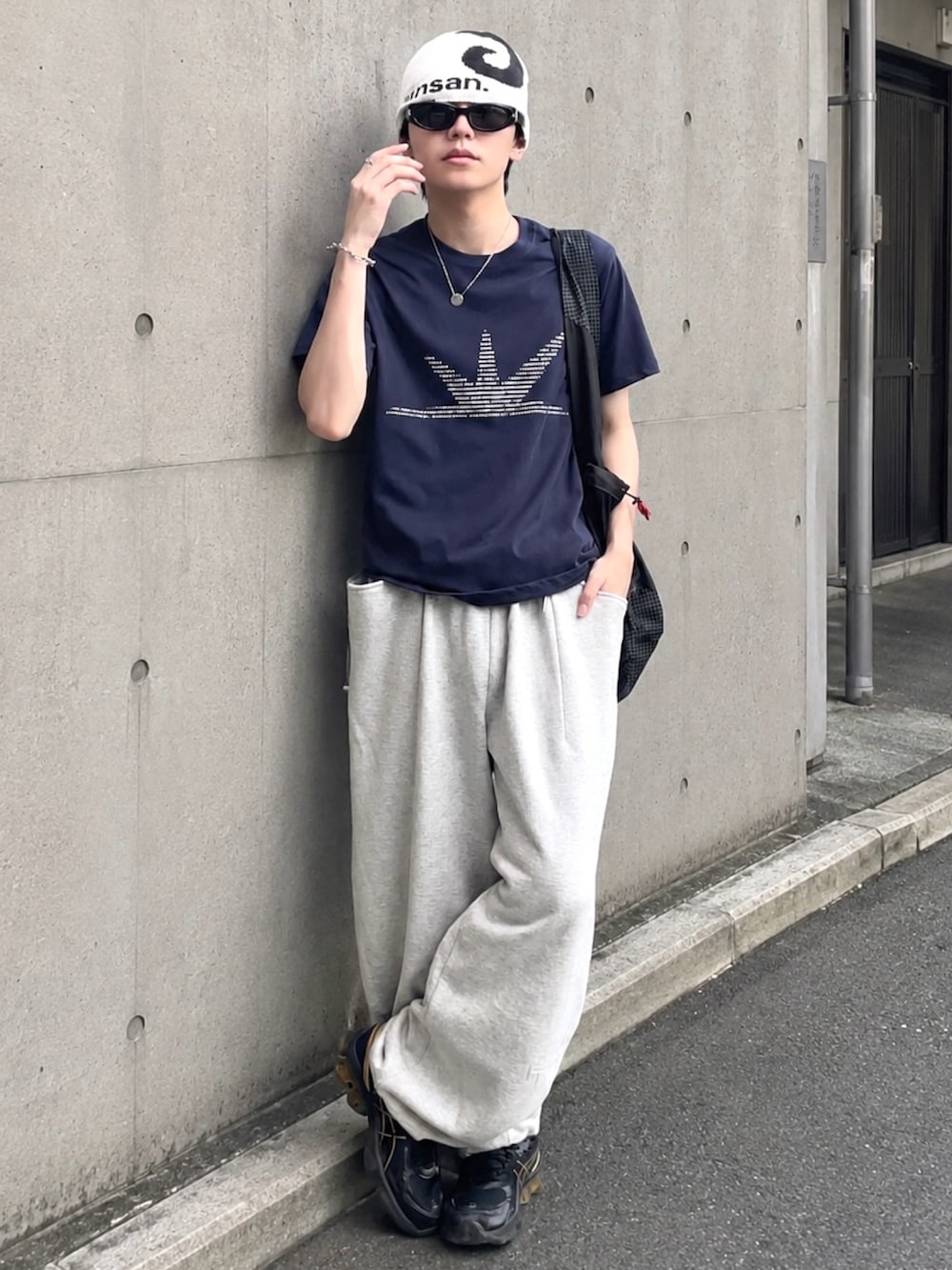 グレー系のスウェットパンツ、ブルー系のTシャツ/カットソー、ブラック系のショルダーバッグを着用したメンズの夏コーディネートの2枚目の写真
