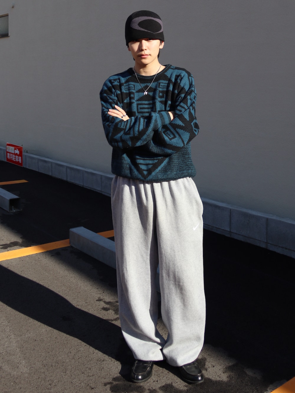 ブラック系のローファー、ブルー系のニット/セーター、グレー系のスウェットパンツを着用したメンズの秋コーディネートの2枚目の写真