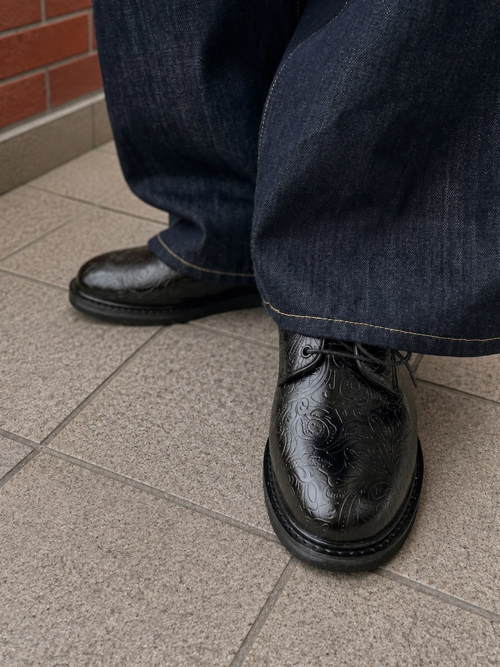 ブラック系のショルダーバッグ、ブルー系のデニムパンツ、ブラック系のドレスシューズを着用したメンズの夏コーディネートの4枚目の写真