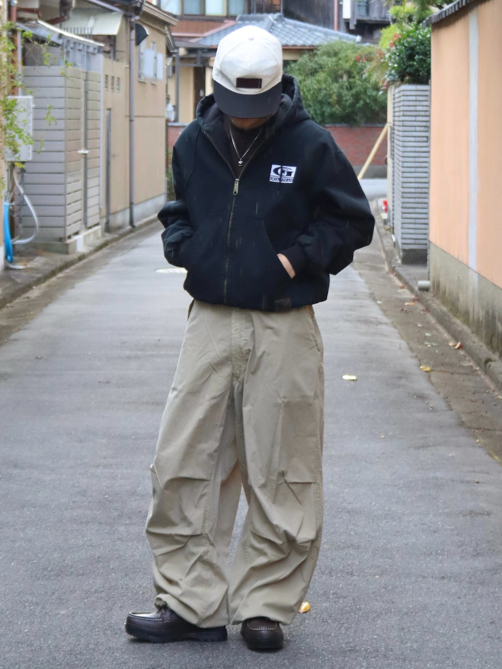 ブラウン系のTシャツ/カットソー、ベージュ系のカーゴパンツ、ブラウン系のブーツを着用したメンズの秋コーディネートの3枚目の写真