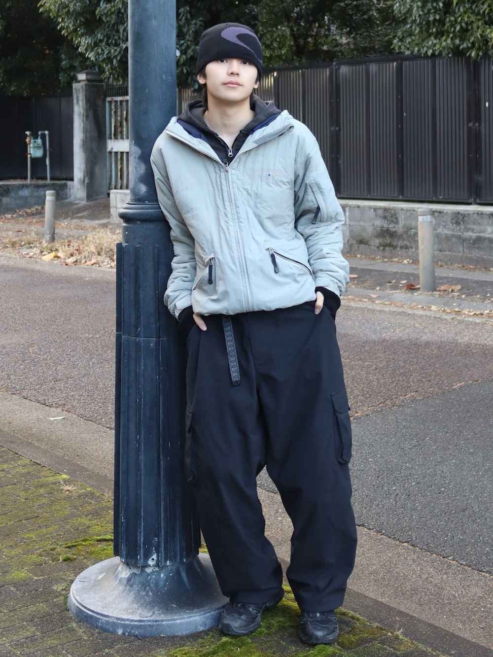 ブラック系のスニーカー、ブラック系のカーゴパンツ、ブラック系のパーカーを着用したメンズの冬コーディネートの3枚目の写真