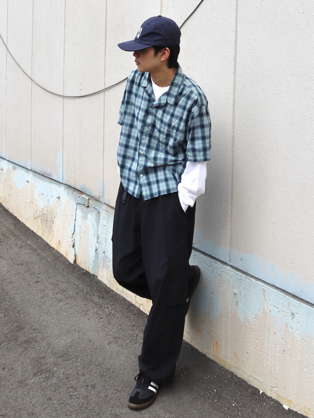 ホワイト系のTシャツ/カットソー、ブラック系のカーゴパンツ、ブラック系のスニーカーを着用したメンズの秋コーディネートの3枚目の写真