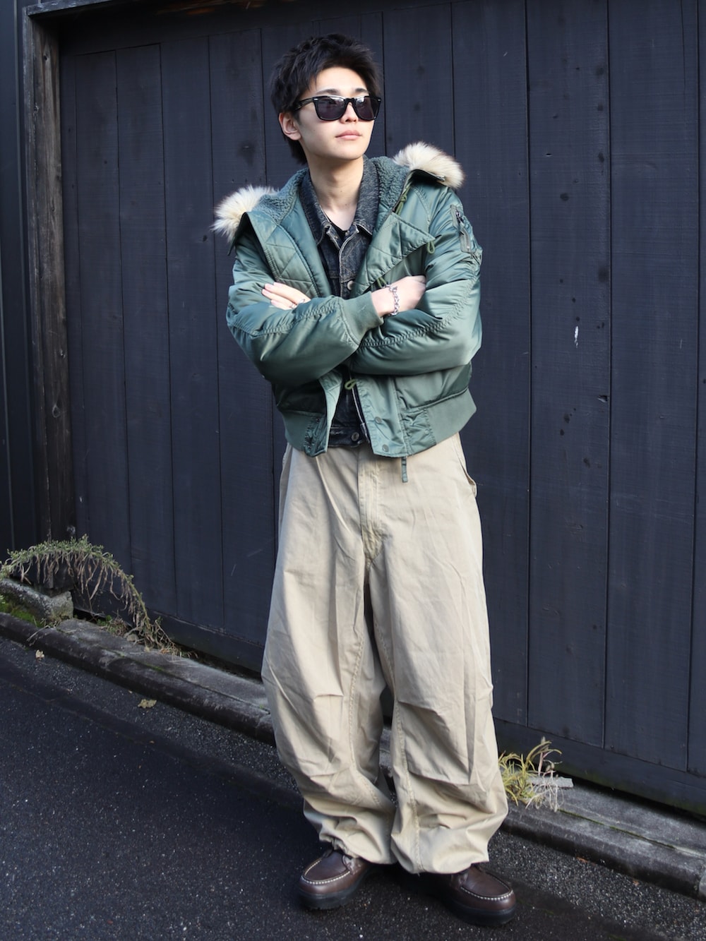 ベージュ系のカーゴパンツ、ブラウン系のブーツ、ブラック系のデニムジャケットを着用したメンズの冬コーディネートの2枚目の写真