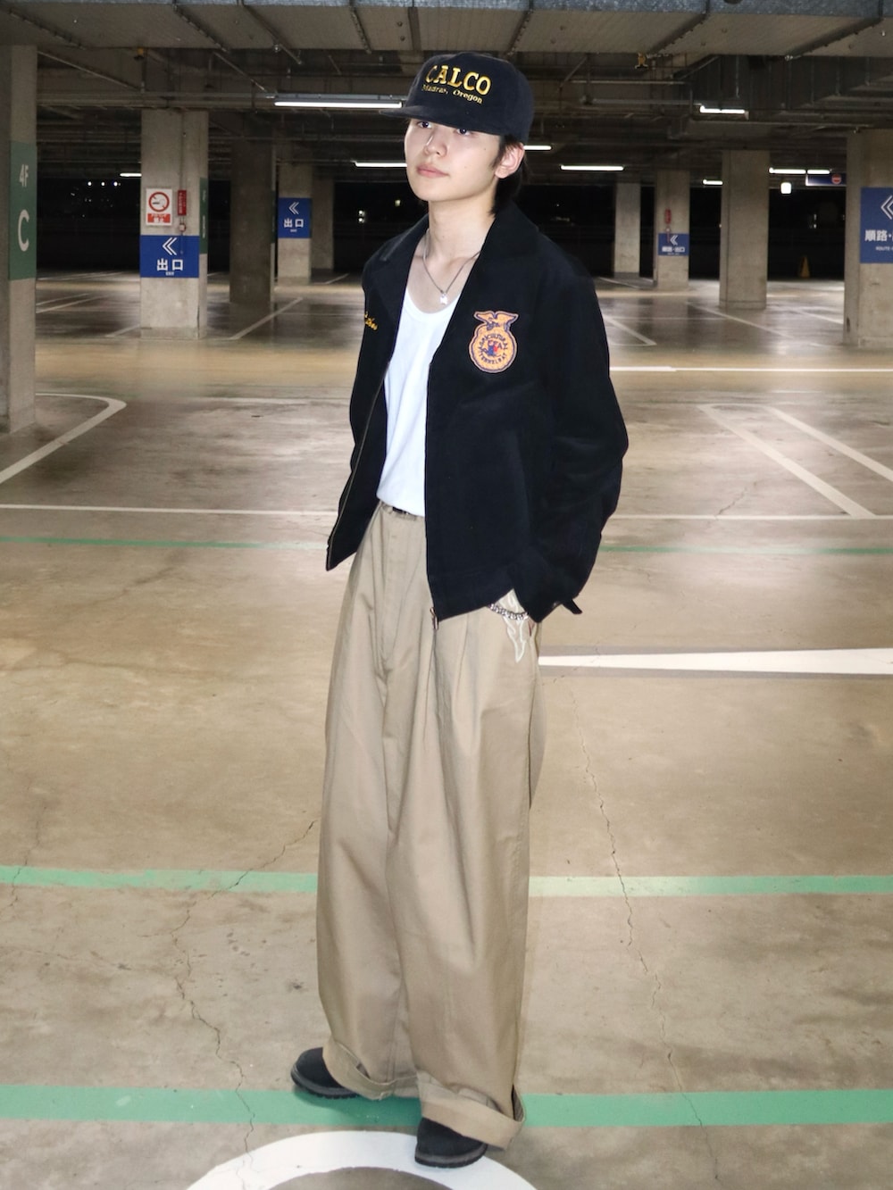 ブラック系のミリタリージャケット、ベージュ系のチノパンツ、ブラック系のブーツを着用したメンズの秋コーディネートの4枚目の写真