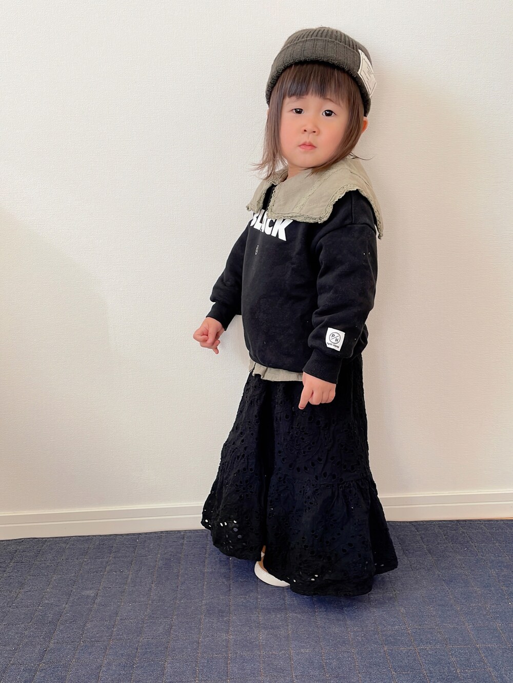 ブラック系のスウェット、グリーン系のシャツ/ブラウス、ブラック系のスカートを着用したキッズの冬コーディネートの2枚目の写真