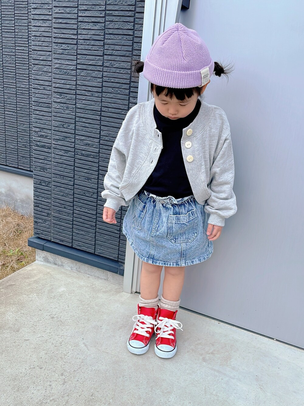 グレー系のカーディガン/ボレロ、ブラック系のワンピース、その他のデニムスカートを着用したキッズの春コーディネートの2枚目の写真