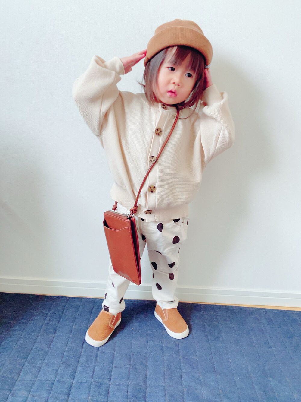 ホワイト系のカーディガン/ボレロ、ホワイト系のその他パンツ、ブラウン系のショルダーバッグを着用したキッズの秋コーディネートの2枚目の写真