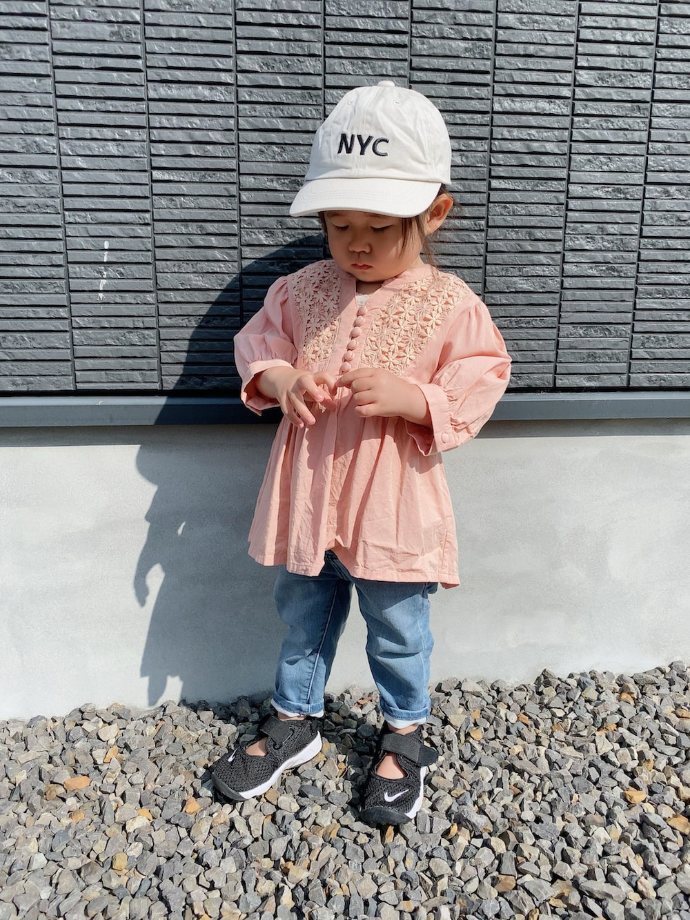 ピンク系のシャツ/ブラウス、ブルー系のデニムパンツ、ブラック系のスニーカーを着用したキッズの春コーディネートの2枚目の写真