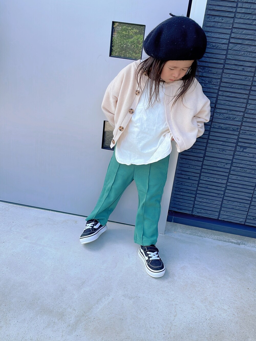 ホワイト系のカーディガン/ボレロ、ホワイト系のTシャツ/カットソー、グリーン系のスラックスを着用したキッズの秋コーディネートの2枚目の写真