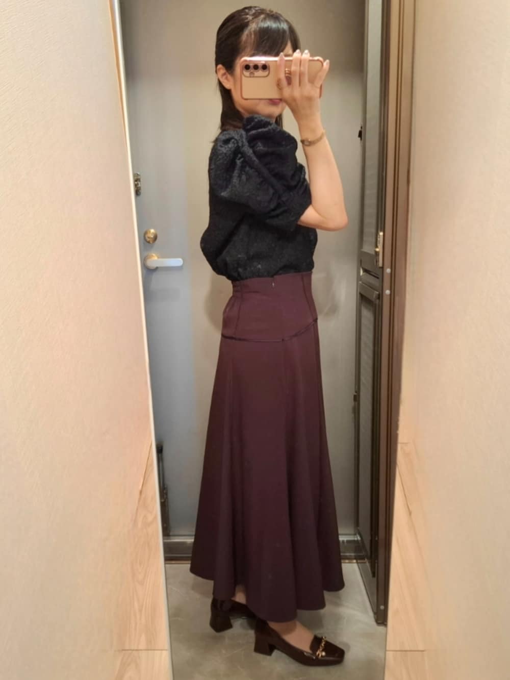 レッド系のスカート、ホワイト系のシャツ/ブラウス、レッド系のパンプスを着用したレディースの秋コーディネートの2枚目の写真