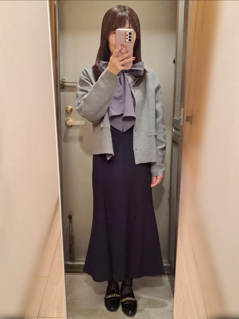 ブラック系のローファー、ブラック系のスカート、グレー系のシャツ/ブラウスを着用したレディースの秋コーディネートの2枚目の写真