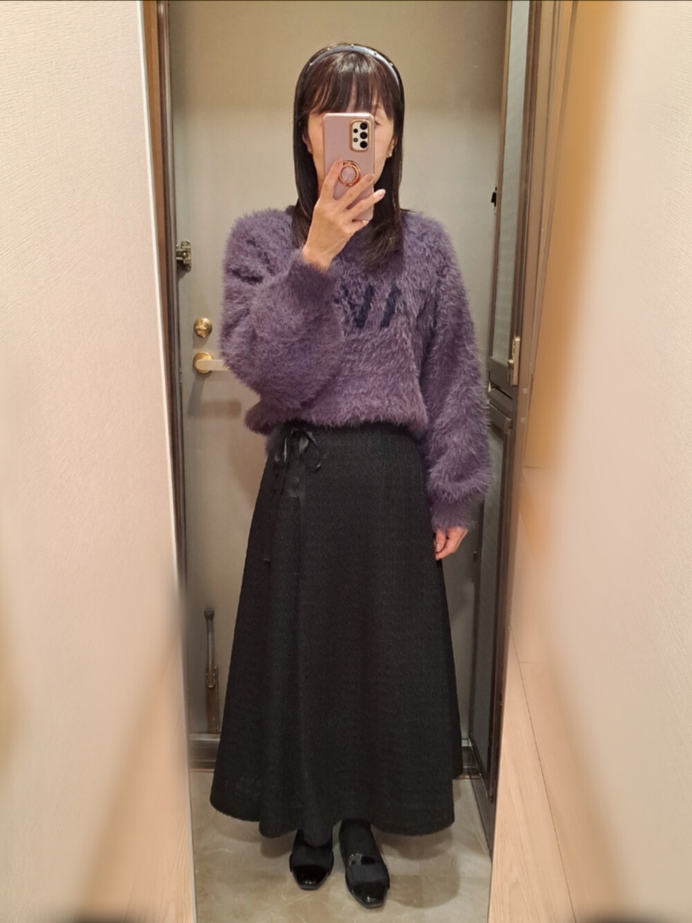 ブラック系のローファー、ブラック系のスカート、グレー系のニット/セーターを着用したレディースの冬コーディネートの2枚目の写真