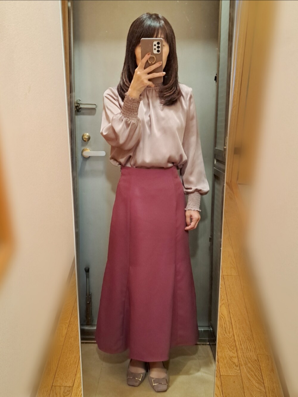 ピンク系のスカート、ベージュ系のパンプス、ピンク系のシャツ/ブラウスを着用したレディースの秋コーディネートの2枚目の写真