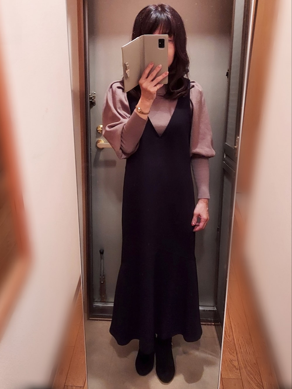 ブラック系のノーカラージャケット、ブラック系のジャンパースカート、ブラック系のブーツを着用したレディースの秋コーディネートの2枚目の写真