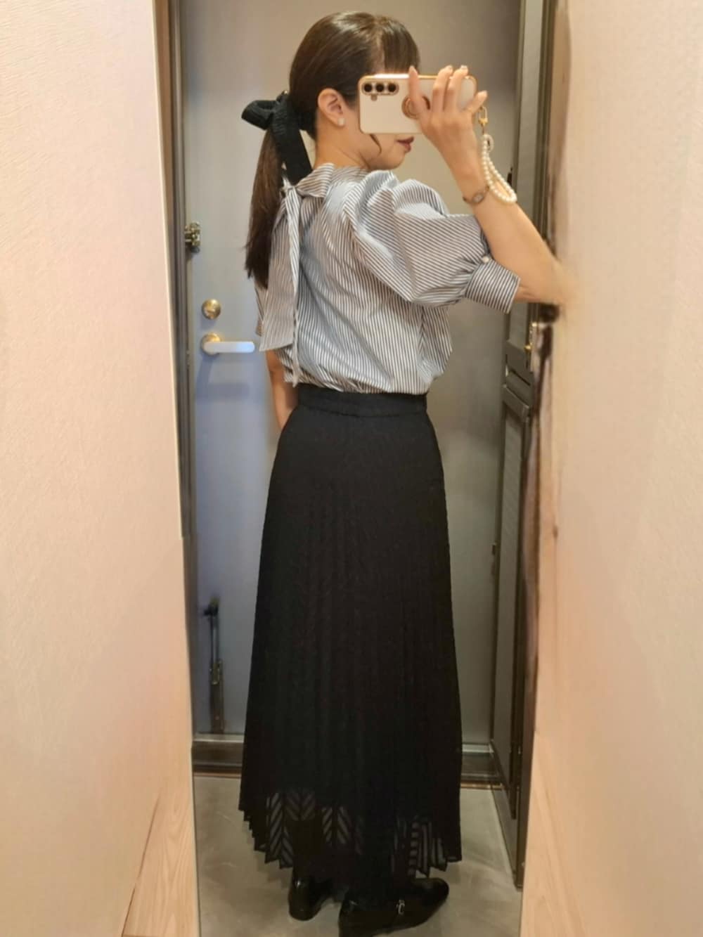 ブラック系のスカート、ブルー系のシャツ/ブラウス、ブラック系のパンプスを着用したレディースの夏コーディネートの2枚目の写真