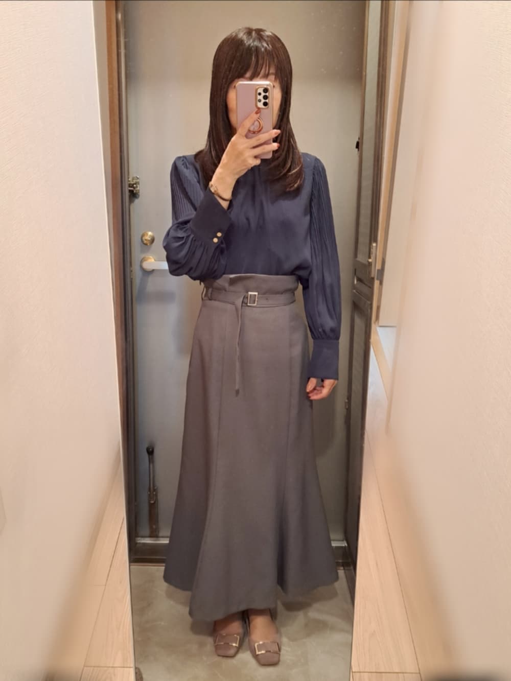 グレー系のスカート、ブルー系のシャツ/ブラウス、ブラウン系のブルゾンを着用したレディースの秋コーディネートの2枚目の写真