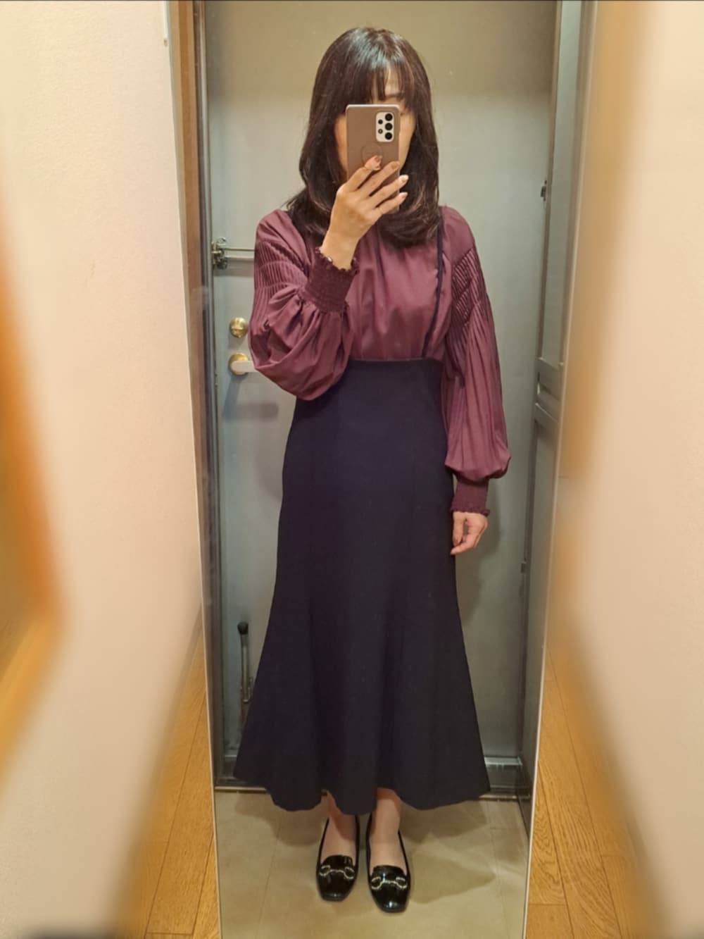 ブラック系のライダースジャケット、レッド系のシャツ/ブラウス、ブラック系のスカートを着用したレディースの秋コーディネートの2枚目の写真