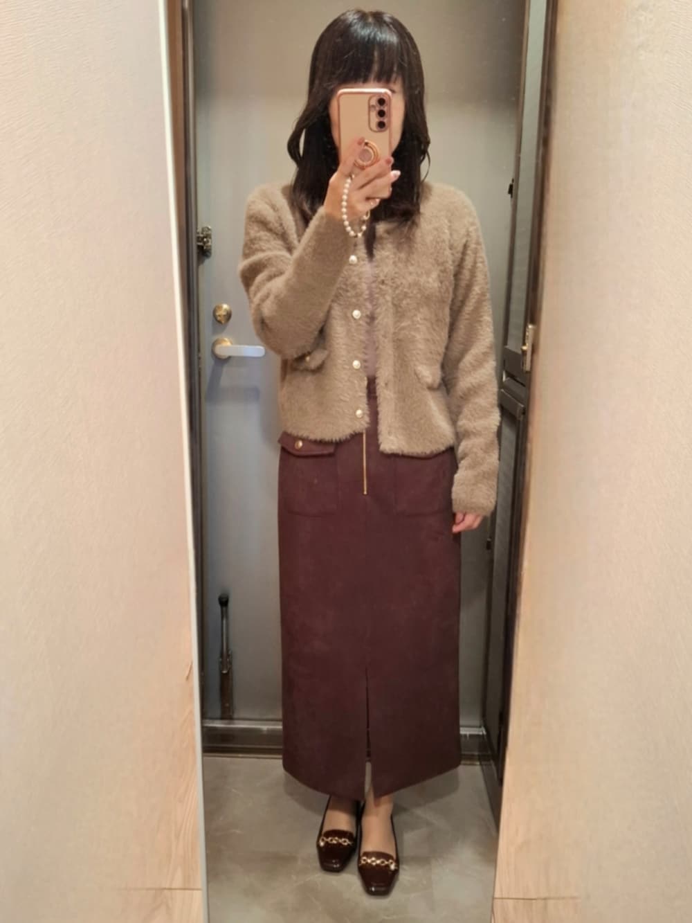 ブラウン系のカーディガン/ボレロ、ブラウン系のスカート、レッド系のパンプスを着用したレディースの秋コーディネートの2枚目の写真