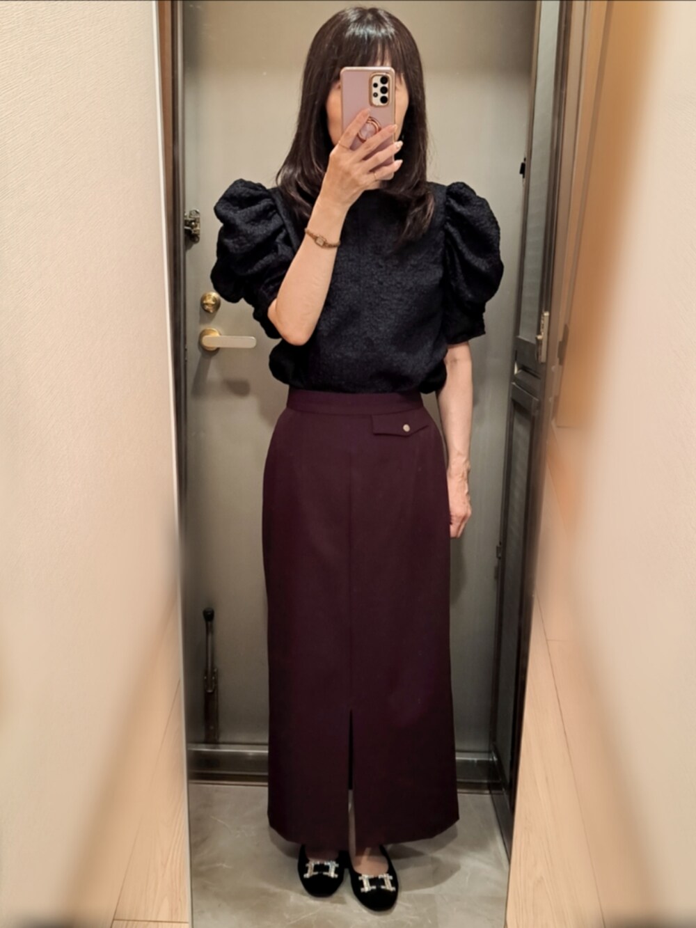 ブラック系のパンプス、レッド系のスカート、ブラック系のカーディガン/ボレロを着用したレディースの秋コーディネートの2枚目の写真