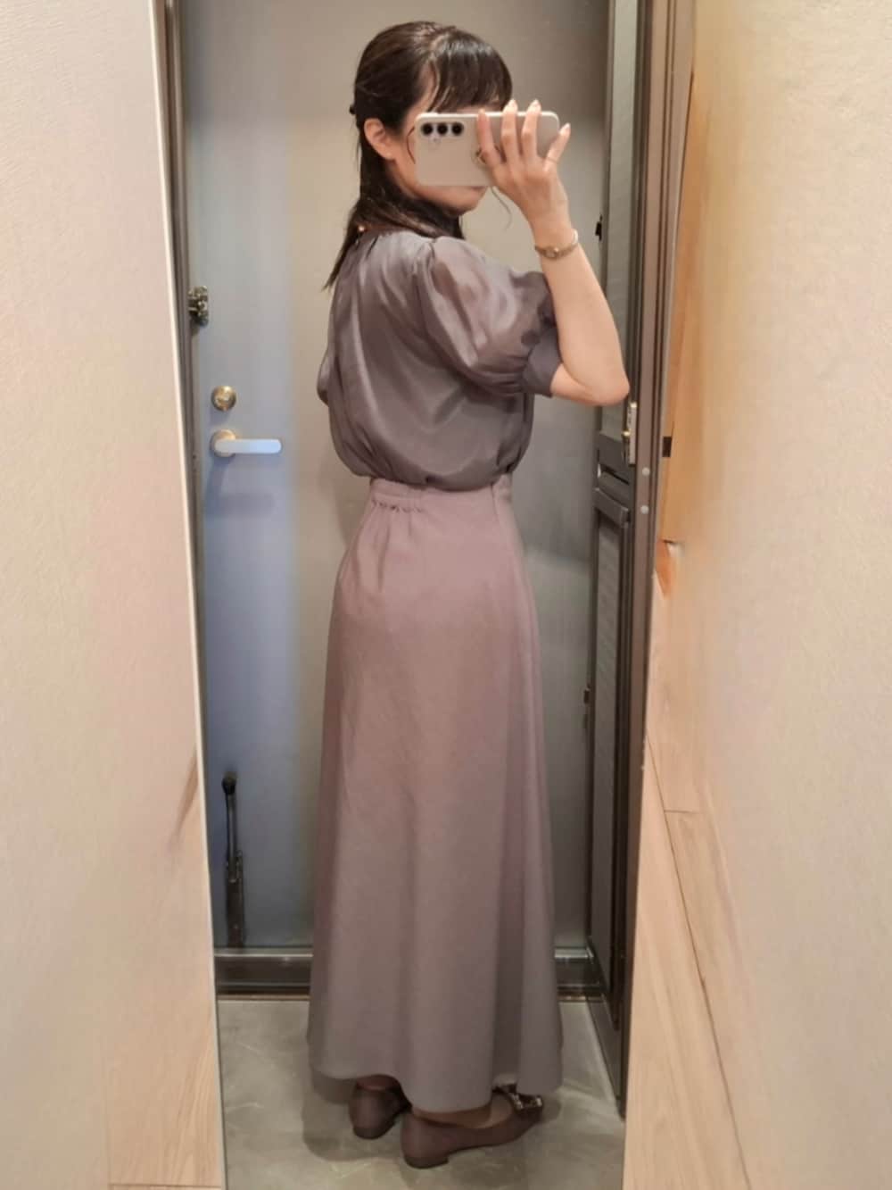 グレー系のシャツ/ブラウス、グレー系のスカート、ベージュ系のパンプスを着用したレディースの夏コーディネートの2枚目の写真