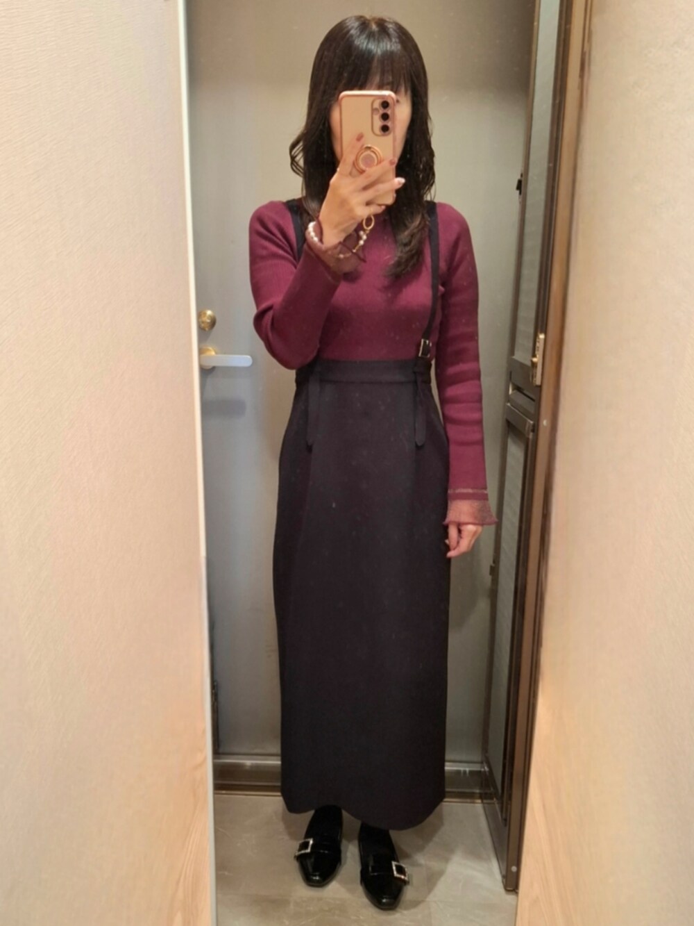 ブラック系のスカート、ブラウン系のテーラードジャケット、レッド系のニット/セーターを着用したレディースの秋コーディネートの2枚目の写真