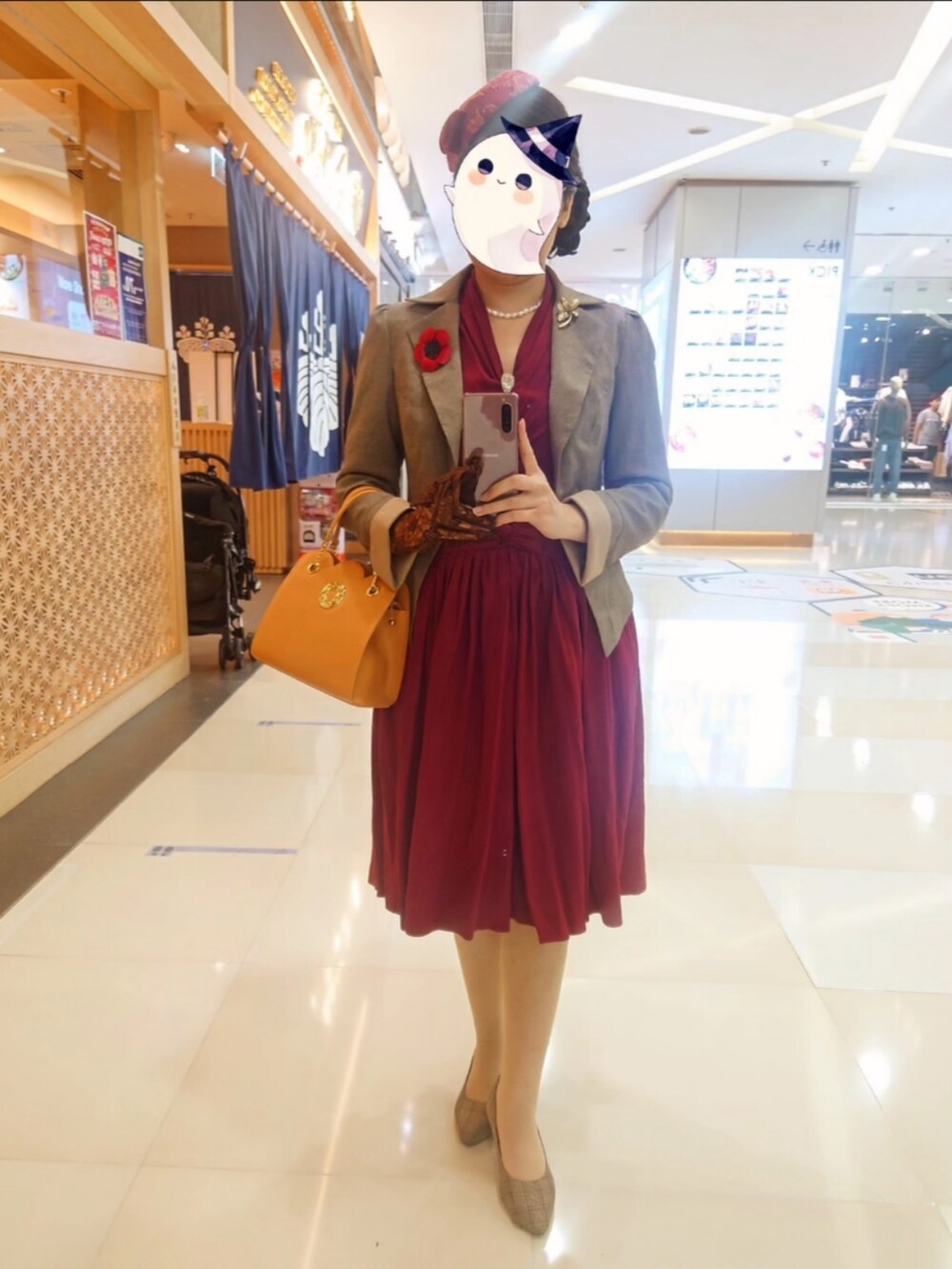 ベージュ系のブーティ、レッド系のワンピース、レッド系のブローチ/コサージュを着用したレディースの冬コーディネートの3枚目の写真