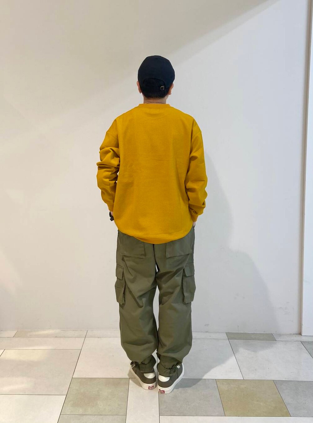 ブラウン系のスニーカー、ブラック系のキャップを着用したメンズの夏コーディネートの3枚目の写真