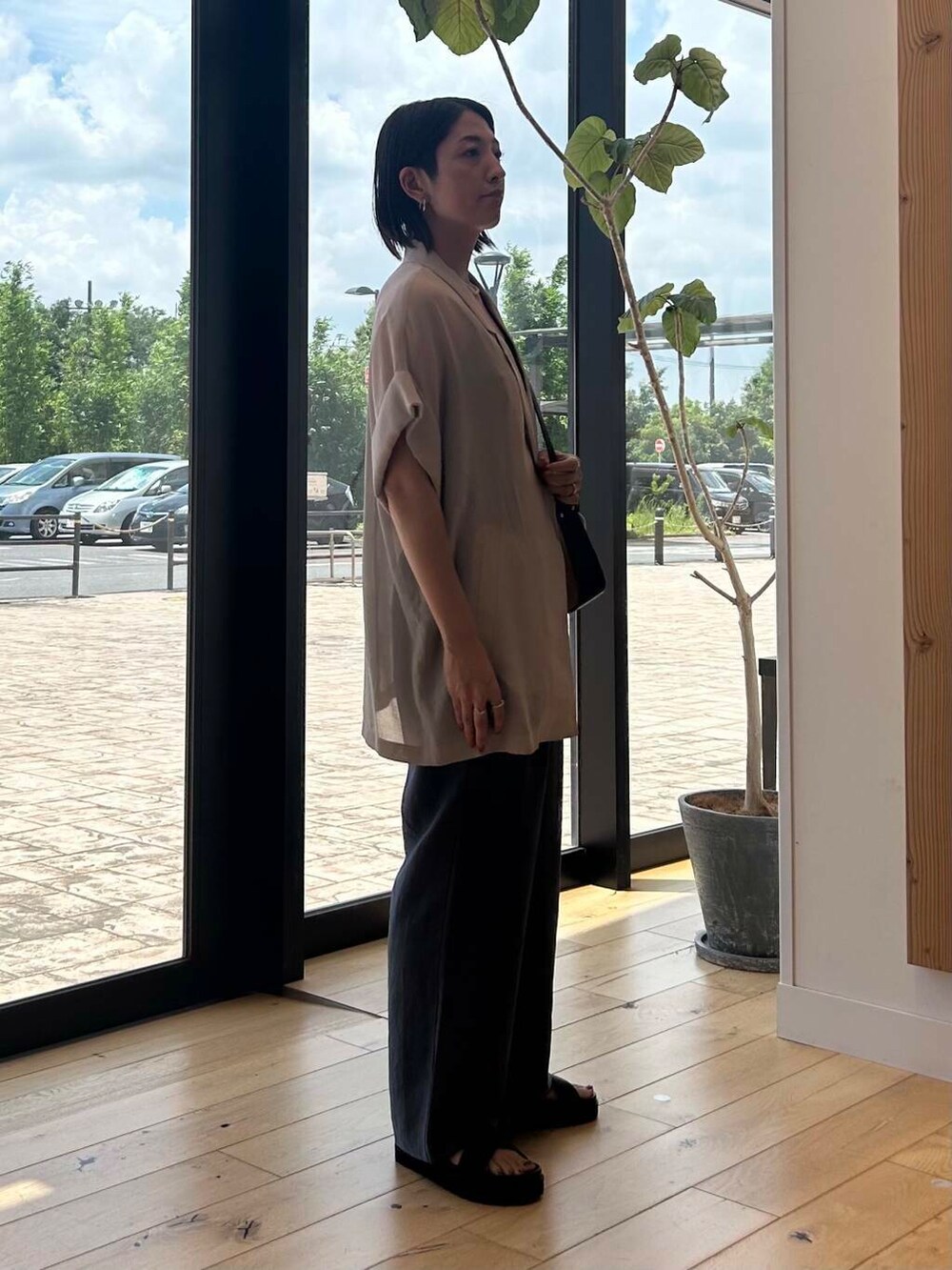 ブラック系のショルダーバッグ、ブラウン系のサンダル、ブルー系のその他パンツを着用したレディースの夏コーディネートの5枚目の写真