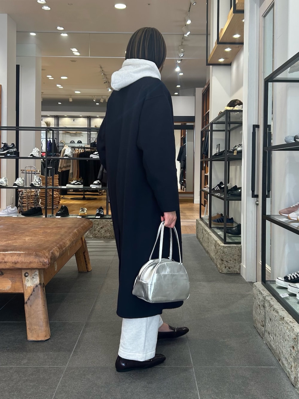 ベージュ系のパーカー、ブラウン系のローファー、シルバー系のボストンバッグを着用したレディースの冬コーディネートの5枚目の写真