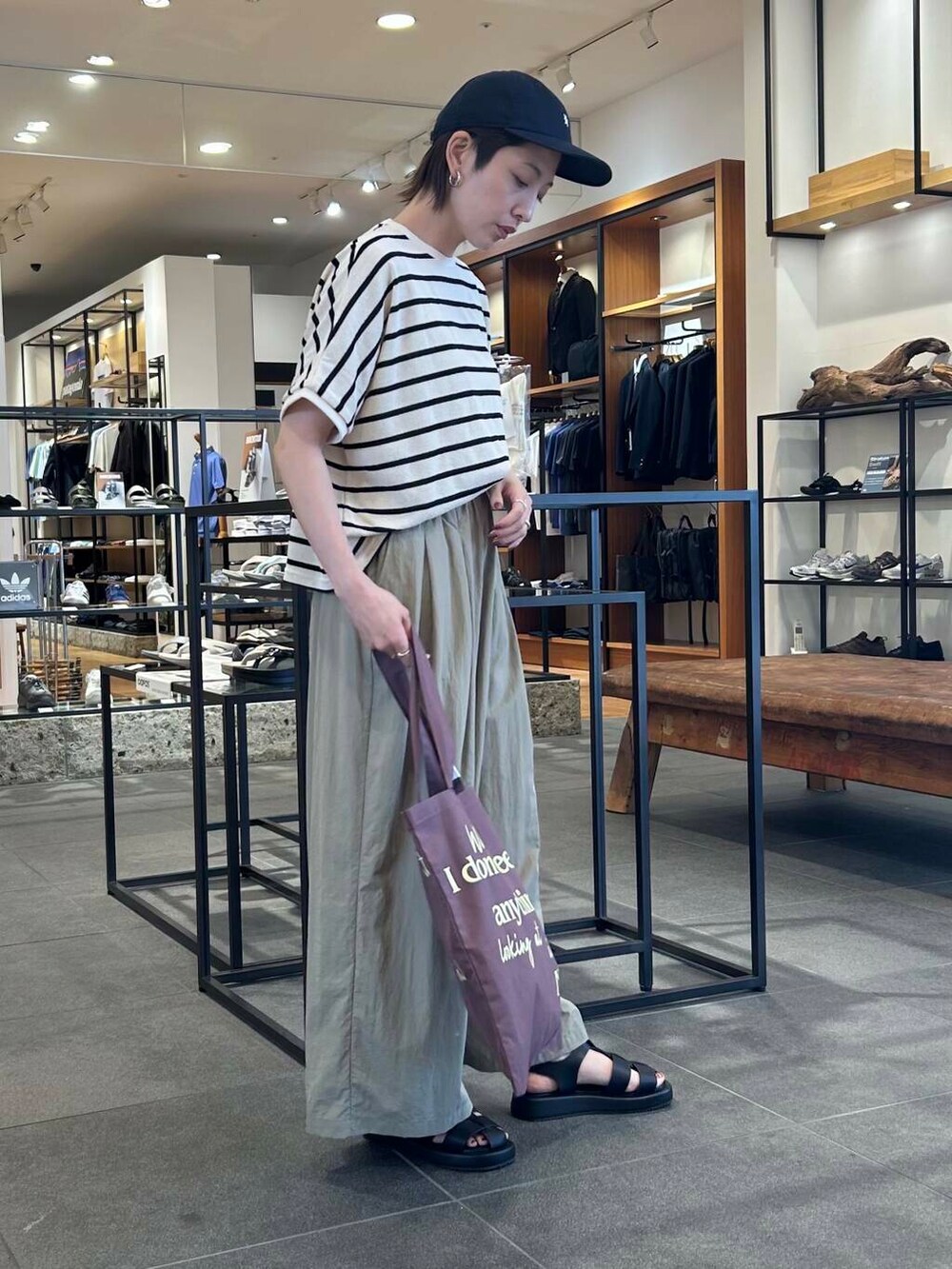 ブラウン系のトートバッグ、ベージュ系のその他パンツ、ブラック系のサンダルを着用したレディースの夏コーディネートの3枚目の写真