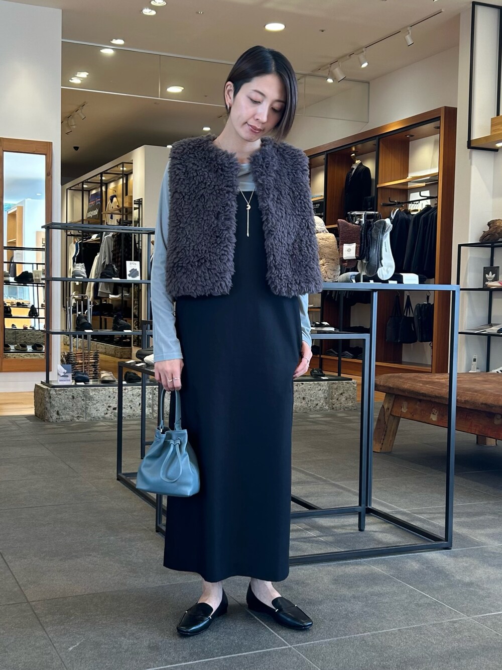 ブラック系のワンピース、ブルー系のショルダーバッグ、ブラック系のローファーを着用したレディースの秋コーディネートの3枚目の写真