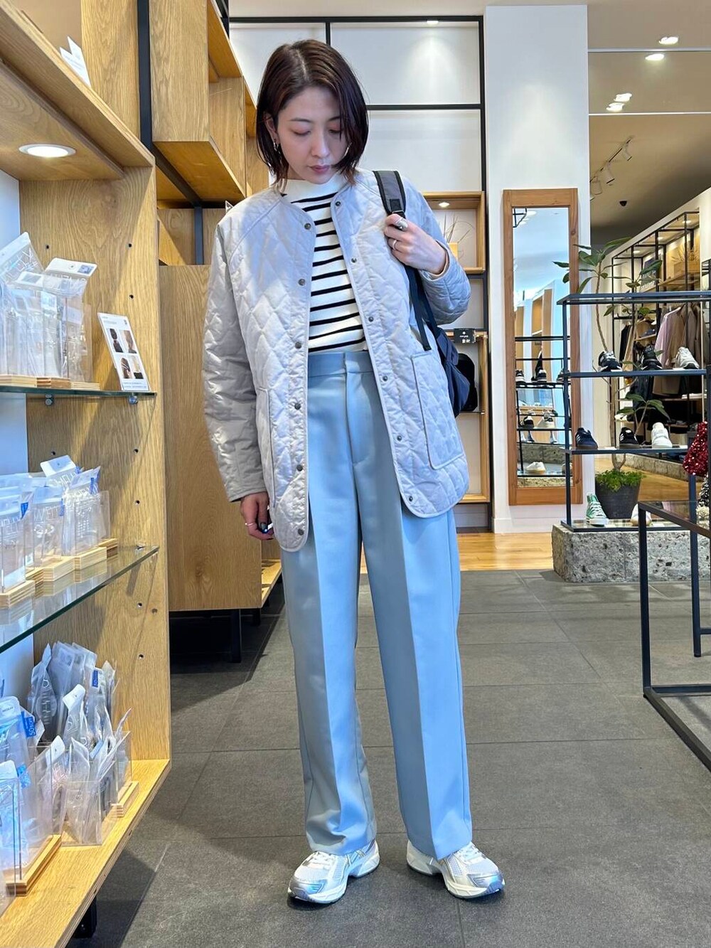 ブルー系のその他パンツ、グレー系のダウンジャケット/コート、ブラック系のニット/セーターを着用したレディースの冬コーディネートの2枚目の写真