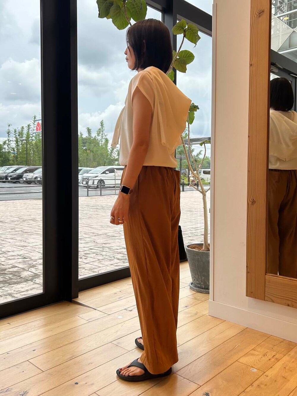 ブラック系のサンダル、ブラック系のトートバッグ、ホワイト系のニット/セーターを着用したレディースの夏コーディネートの4枚目の写真