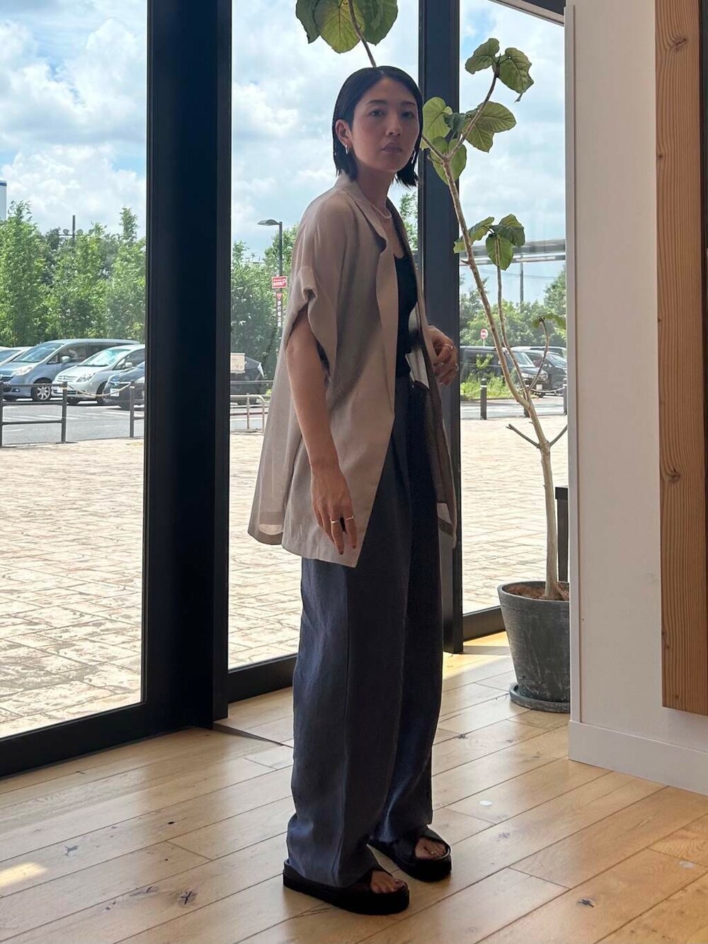 ブラック系のショルダーバッグ、ブラウン系のサンダル、ブルー系のその他パンツを着用したレディースの夏コーディネートの3枚目の写真